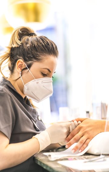 Manicure and pedicure salon with security measures and face masks at the reopening of the pandemic. Coronavirus